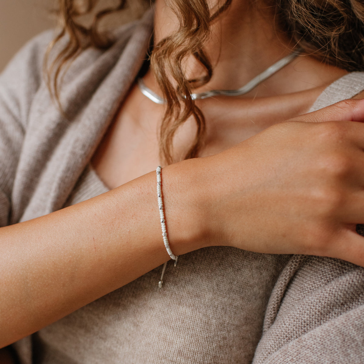 Person wearing a bracelet with a neutral background