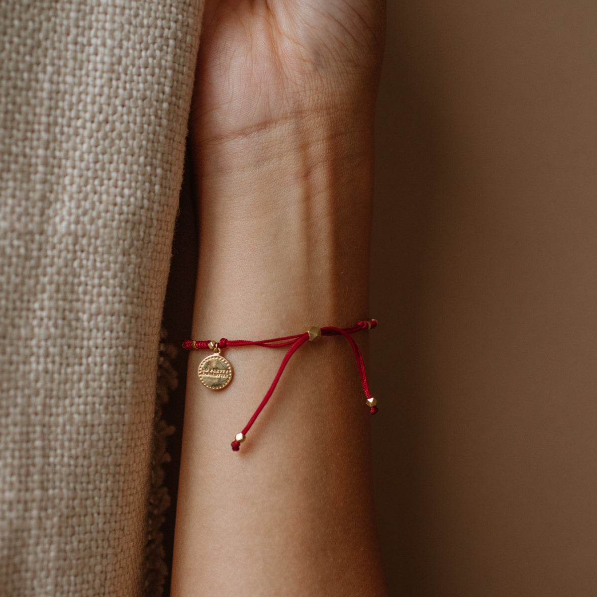 Red bracelet on a wrist with a neutral background