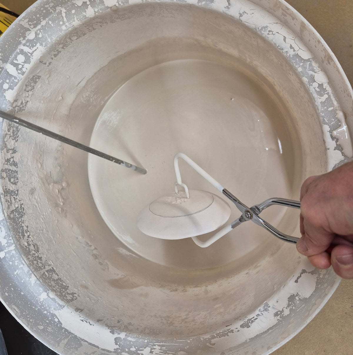 Person holding a hand mixer over a bowl with white batter